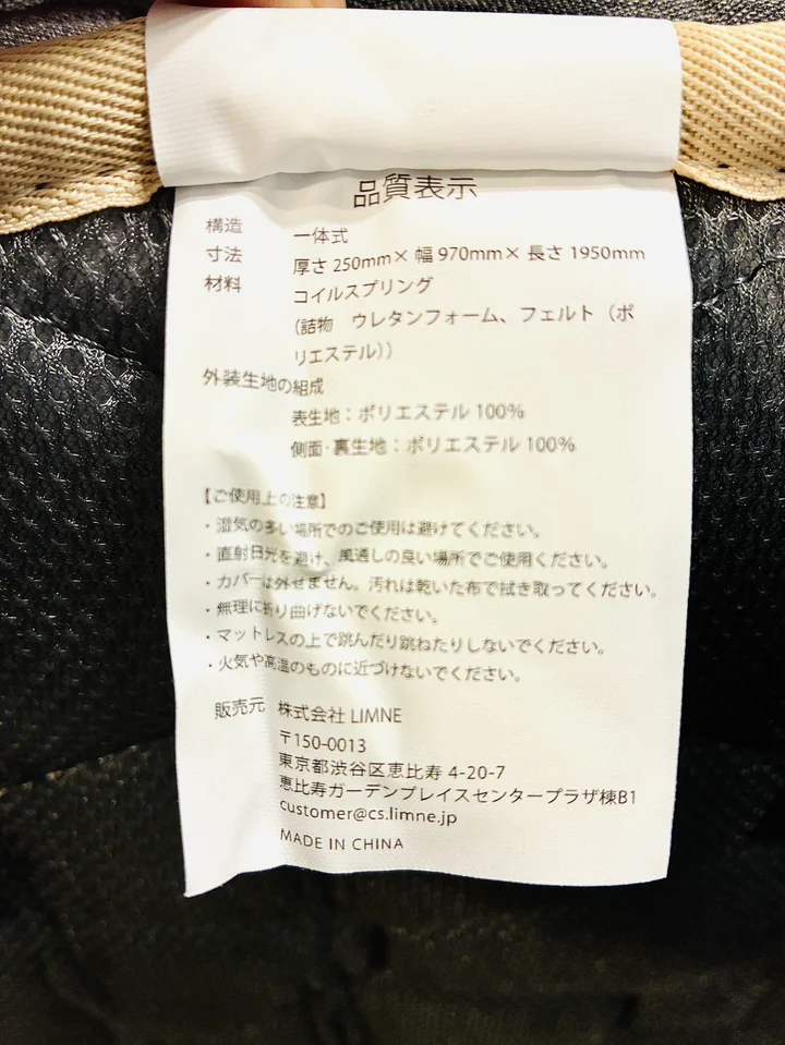 リムネマットレスの品質表示タグ。寸法・材料・使用上の注意が記載されている