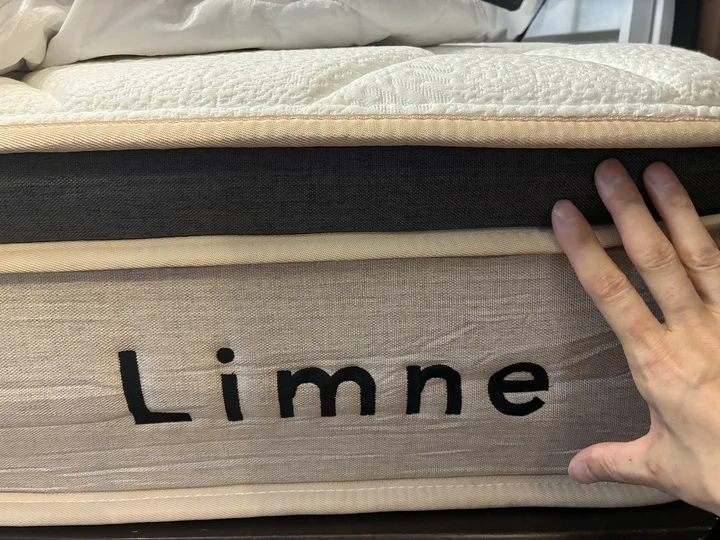 リムネマットレスの側面。白いキルティング層と土台の層、Limneのロゴが見える