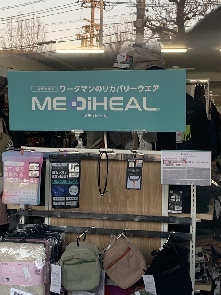 ガラス越しに見たワークマン メディヒールの売場。ルームシリーズの棚がほぼ空で、下の段にはバッグなど別の商品が置かれている
